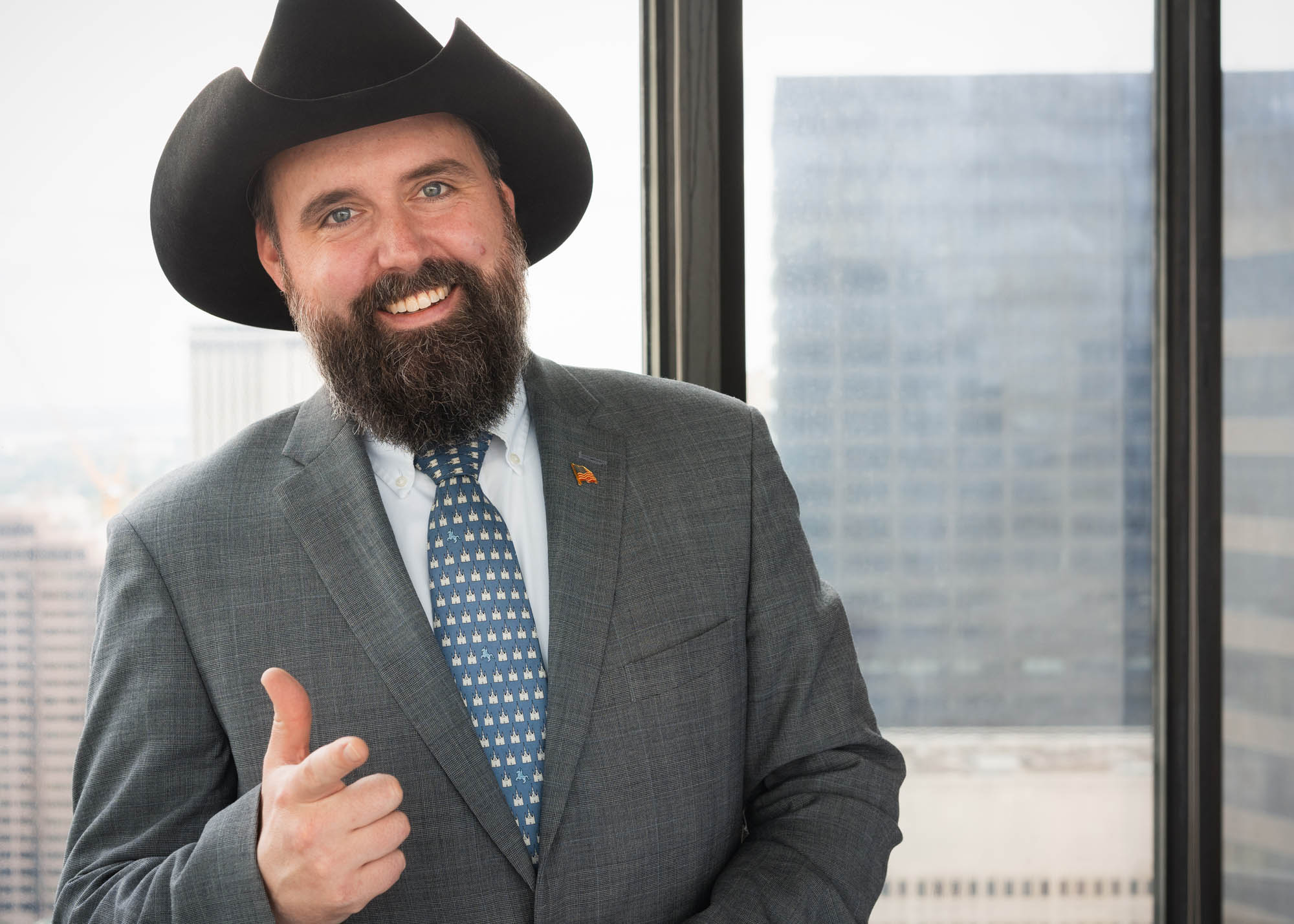 Lawyer smiling wearing a cowboy hat in his Downtown New Orleans office