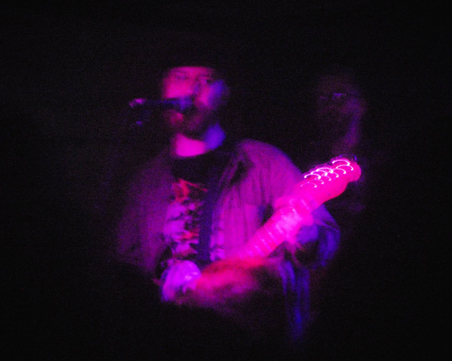 Lead singer of Panchiko playing his guitar at the House of Blues in Nola