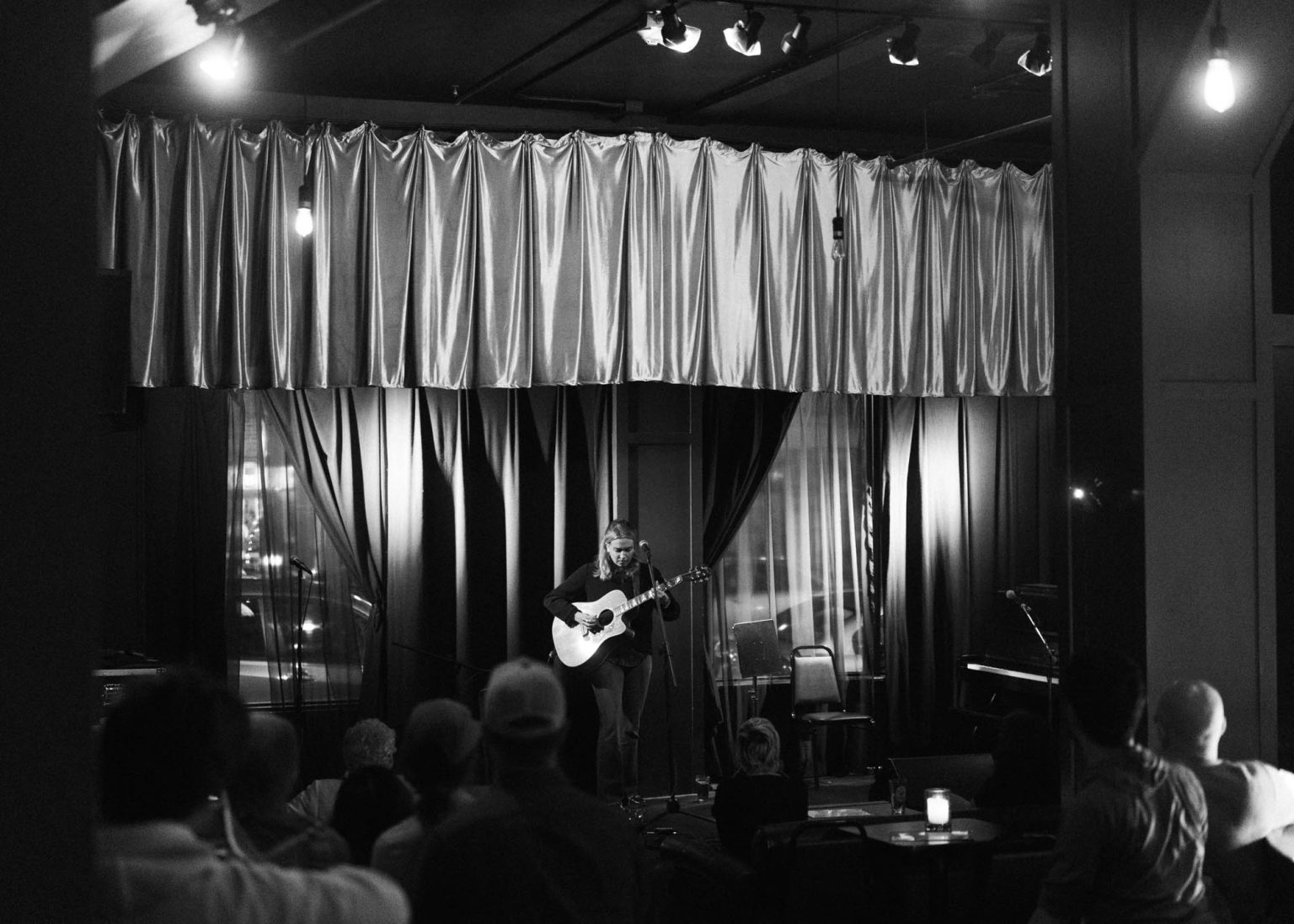 Melanie MacLaren playing guitar on stage during her performance in Portland Maine