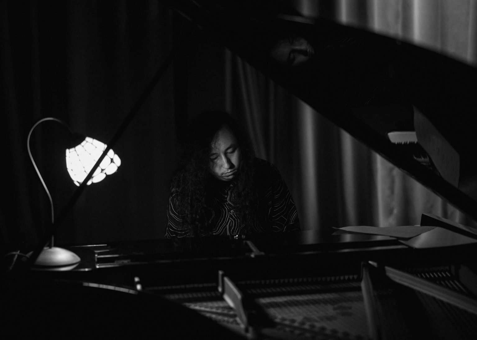 Member of Youse Band playing a grand piano live on stage