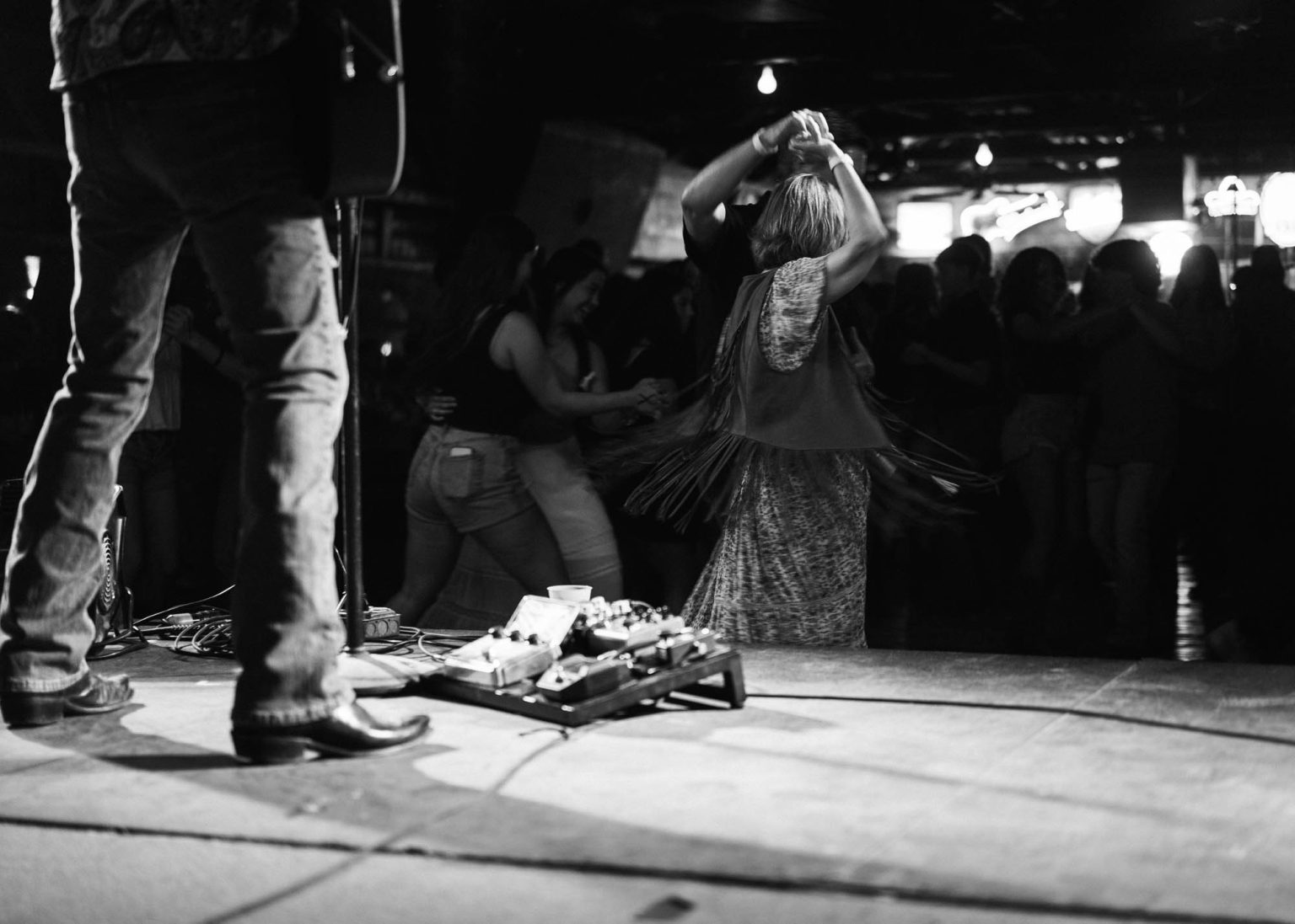 Crowd dancing as band plays their instruments live on stage