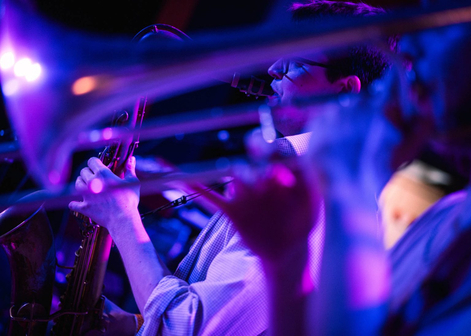 Playing saxophone and trombone on stage in Nola