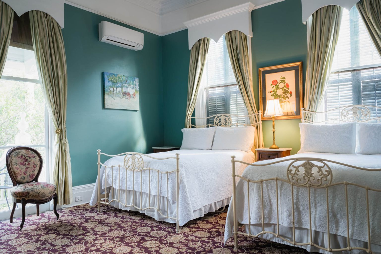 Two bed hotel room in afternoon light with large windows