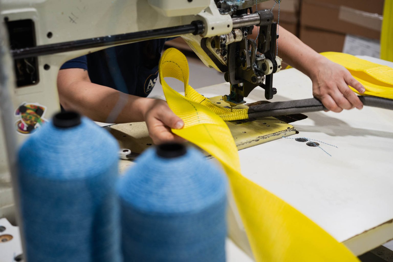 Sewing yellow sling products with blue thread