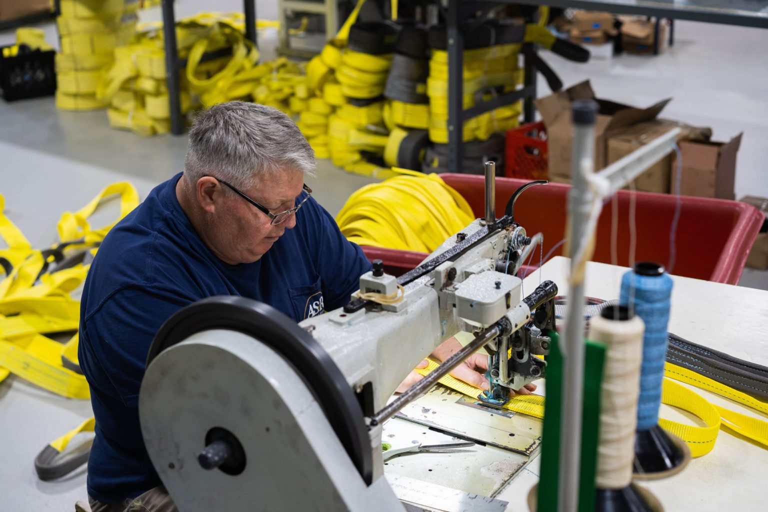 At the sewing machine working on creating yellow slings