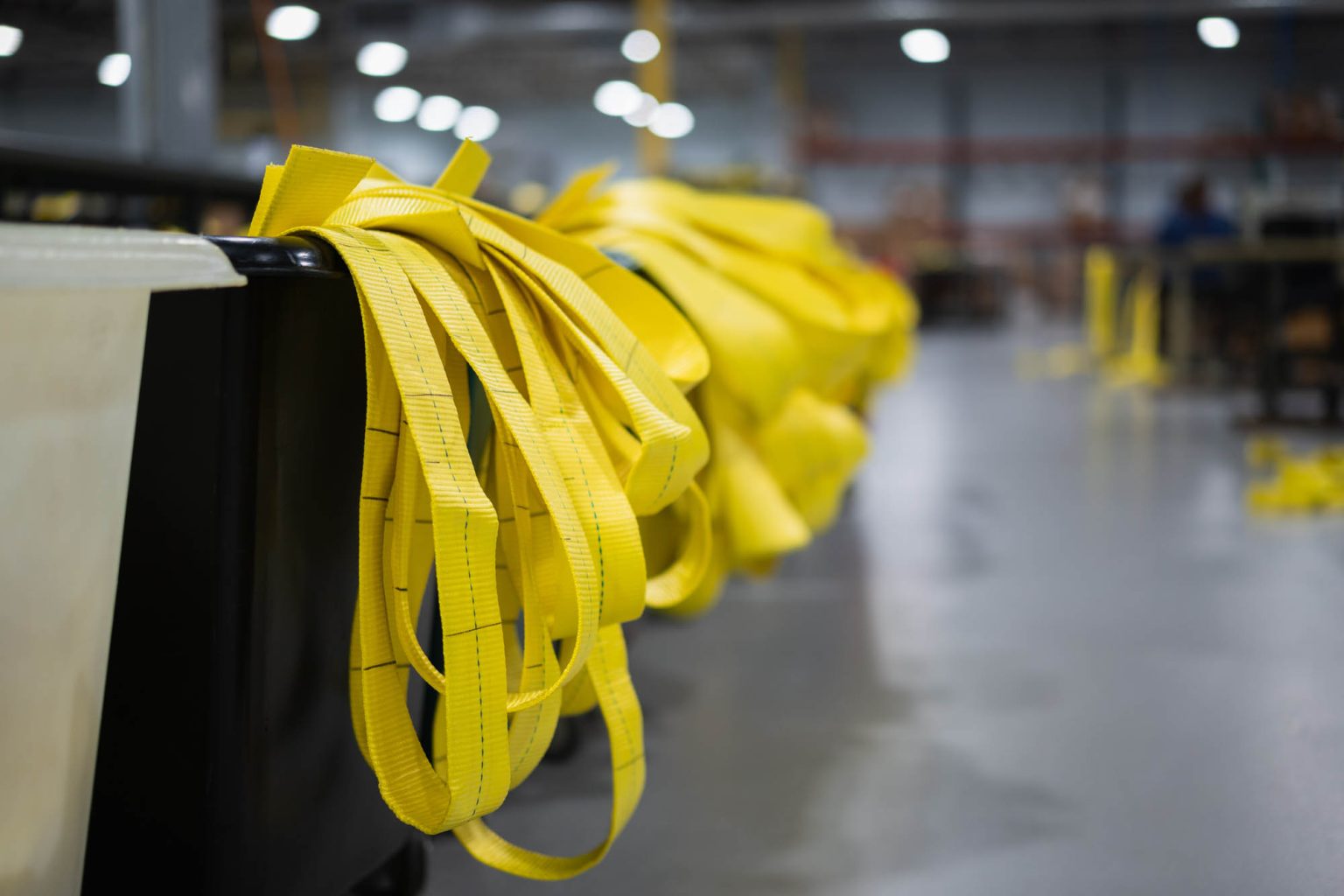 Yellow slings on the side of bins in large facility