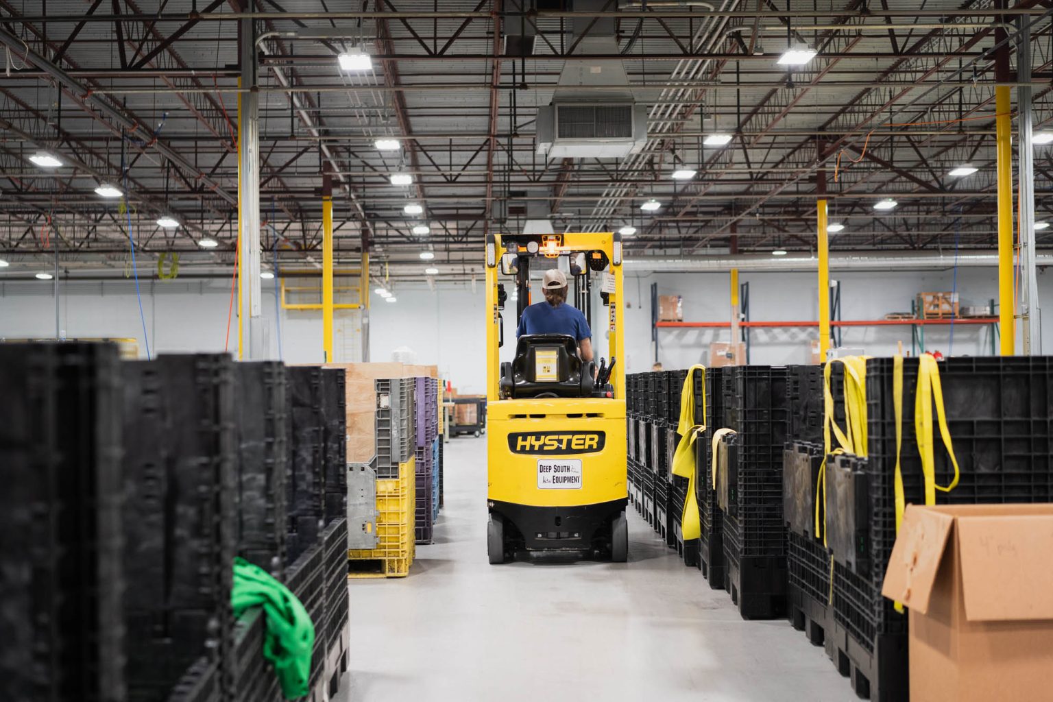 Fork lift going down aisle in large well-lit facility