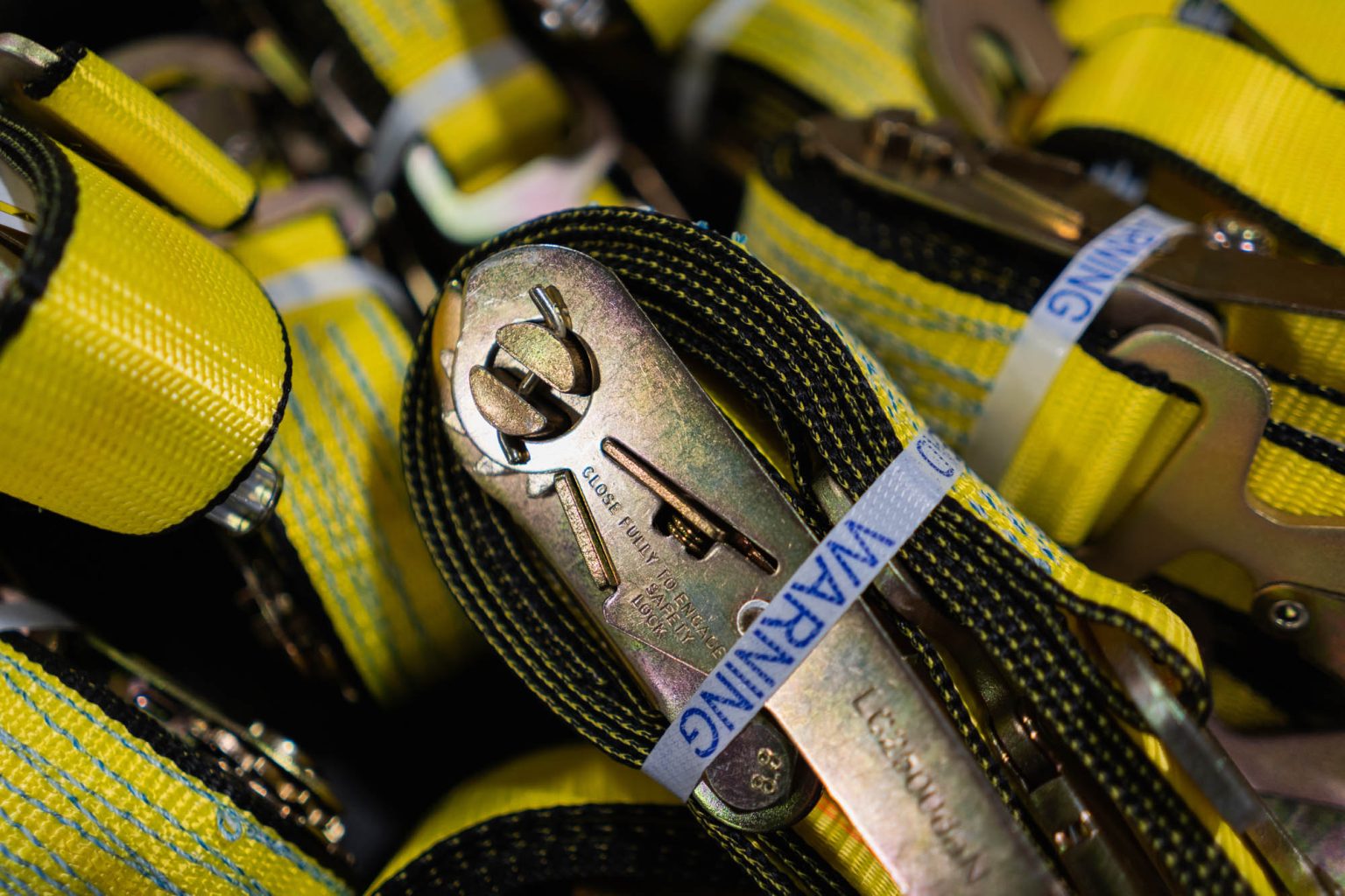 Metal handle on yellow ratchet straps in large bin