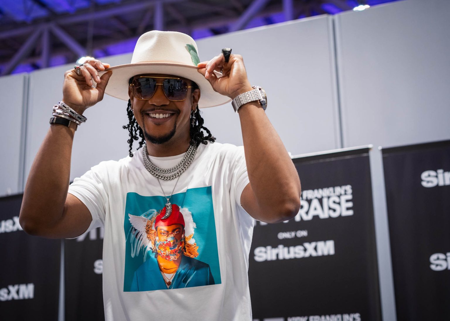 Fixing hat while smiling for a portrait back stage before his interview and performance