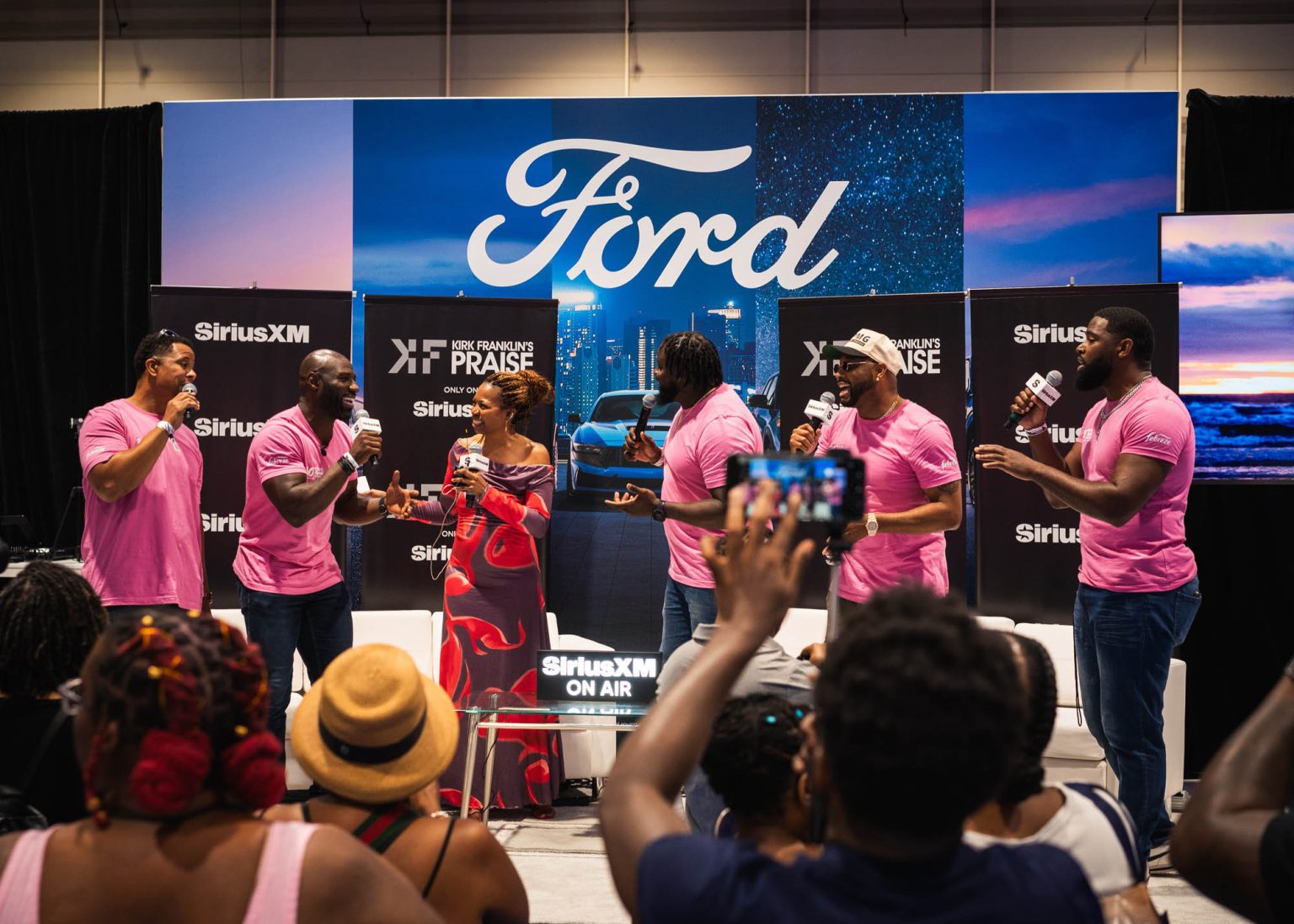 Singing on stage together with a crowd in the foreground during Essence Festival 2024 in New Orleans