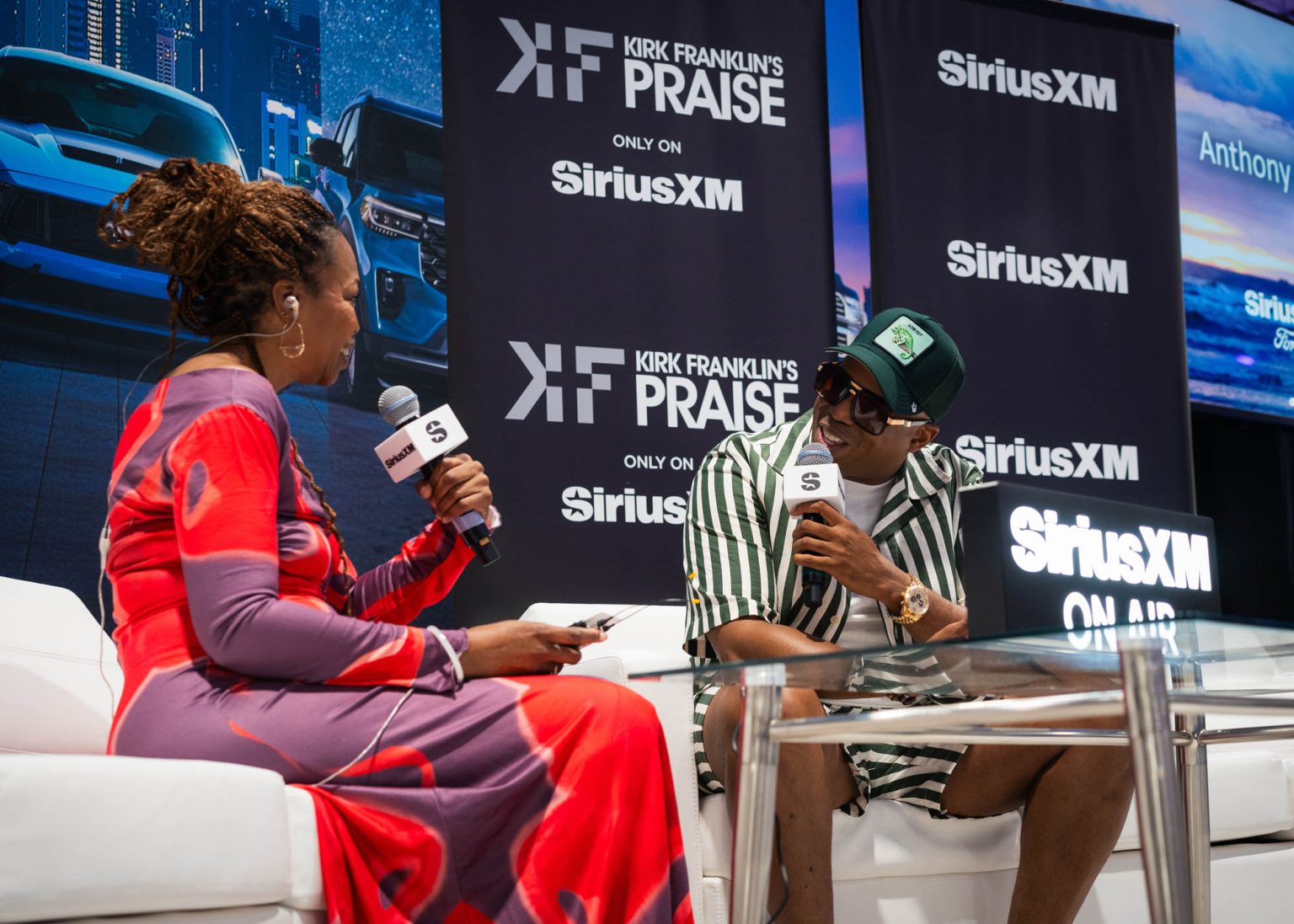 On stage artist interview sitting on couches and holding microphones