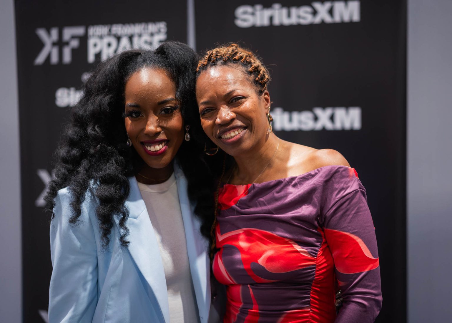 Smiling together with the Kirk Franklin's Praise banner in the background