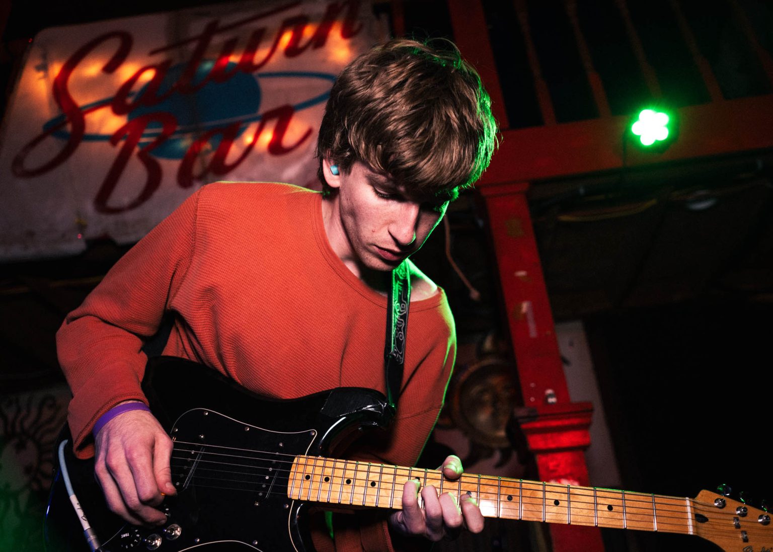 Guitarist playing notes on the fret board while performing on stage