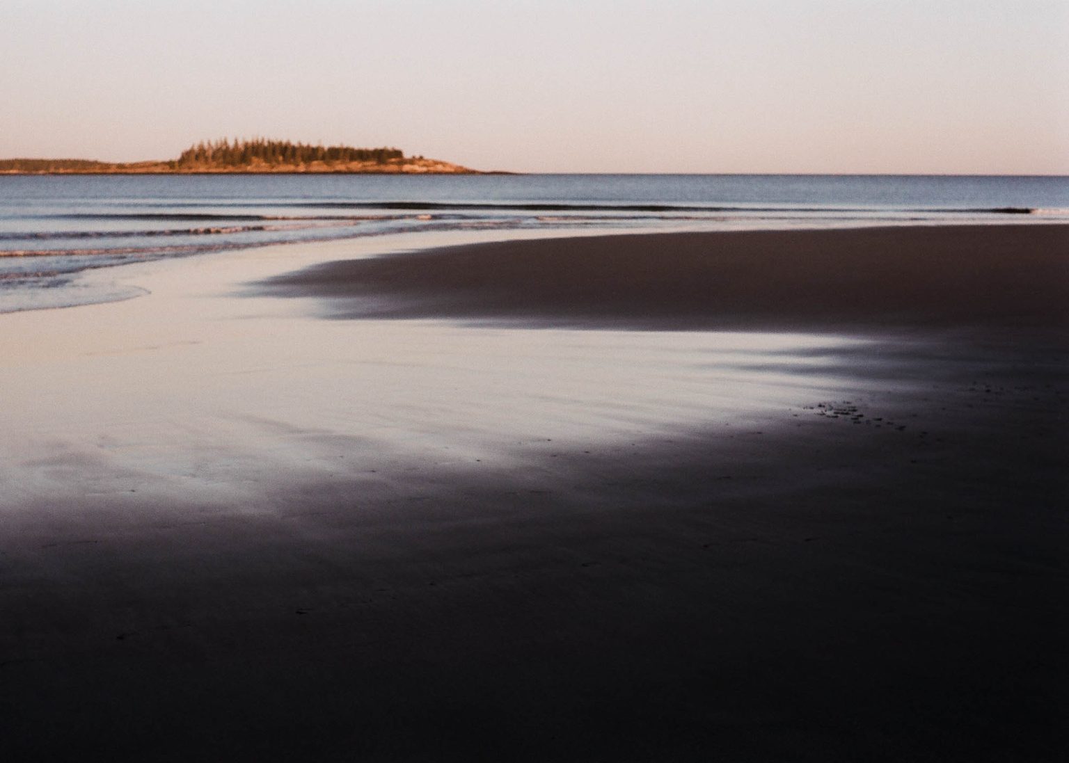 Low tide at a dark beach along the coast of Maine near sunset